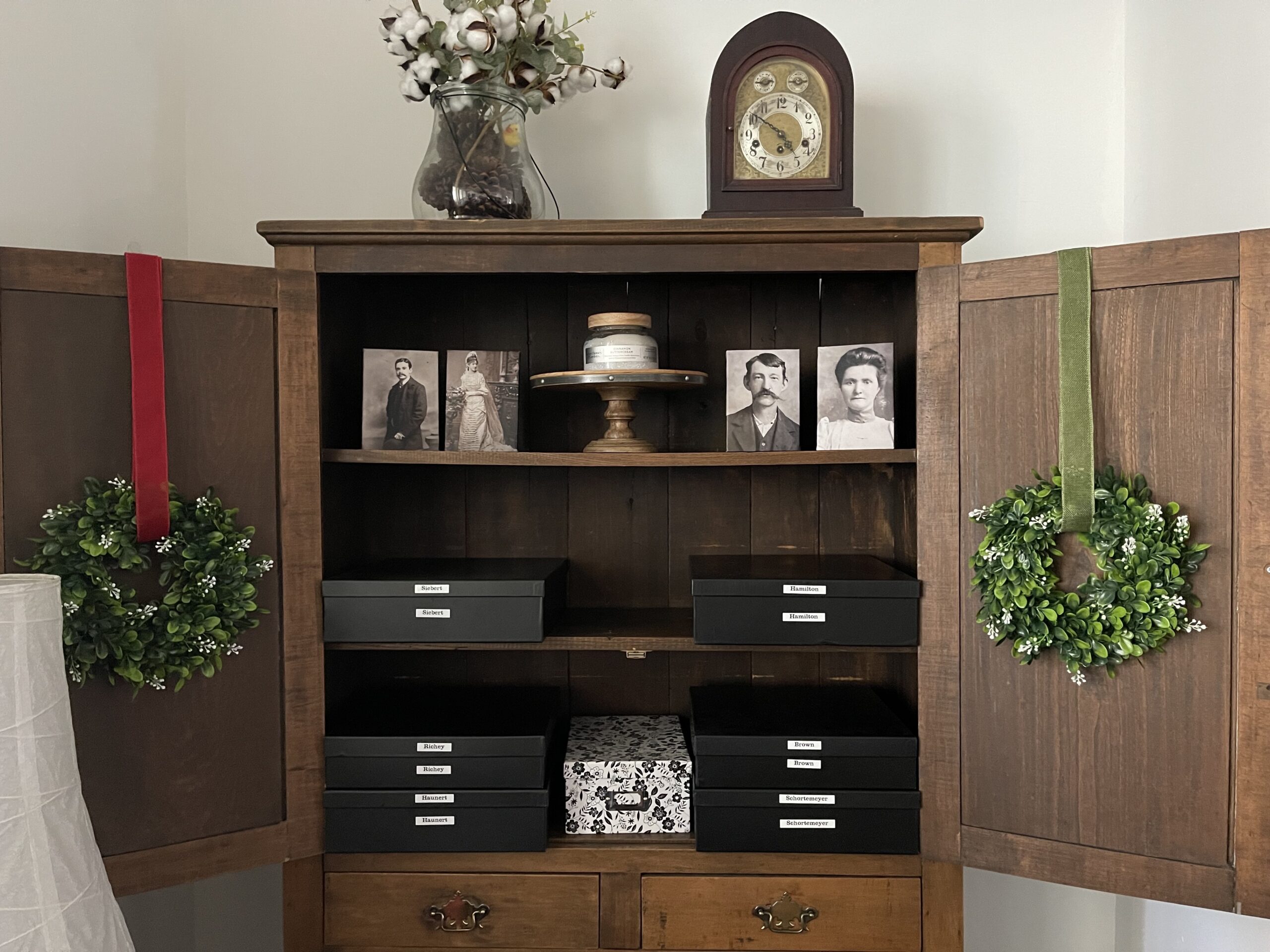 Family history cabinet with archival boxes, labels, and canvas prints.